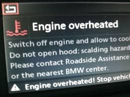 A Dashboard warning light showing an overheated engine in a BMW car