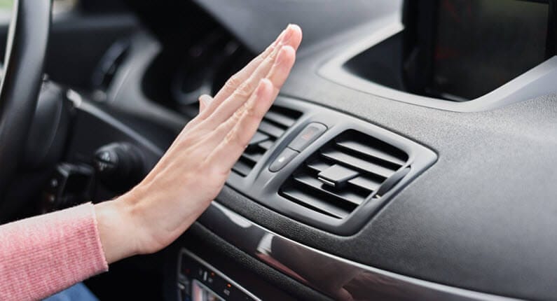 A women is checking air from air conditioner of a car – German Car Depot A women is checking air from air conditioner of a car