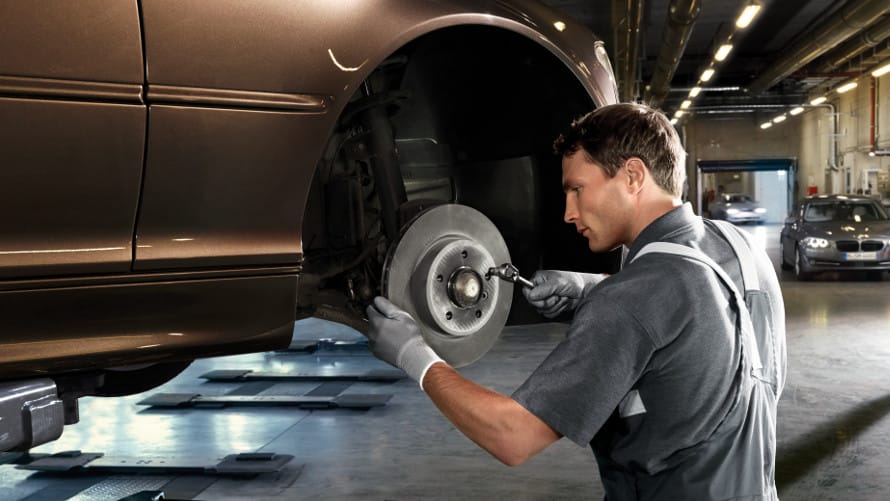 A Mechanic is fixing car's brake rotors in a mechanics shop