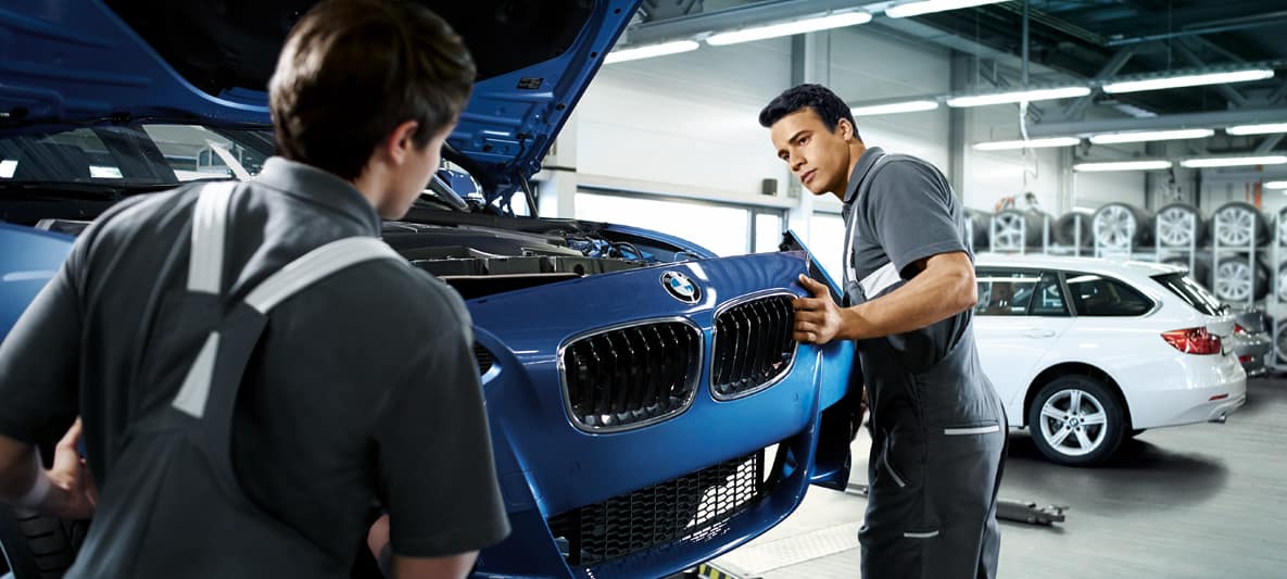 A mechanic fitting a BMW's body