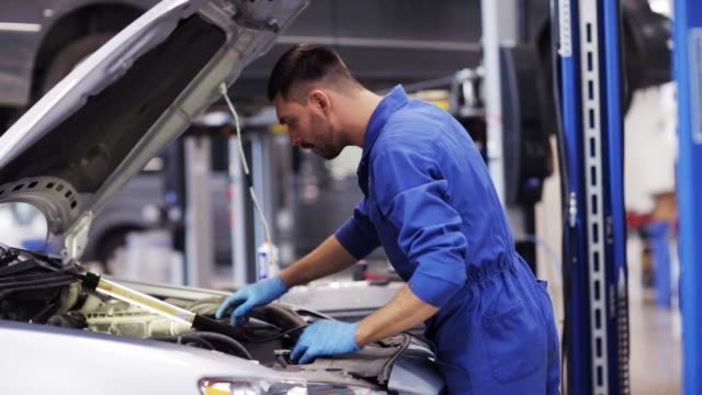 A mechanic checking car engine in auto repair shop